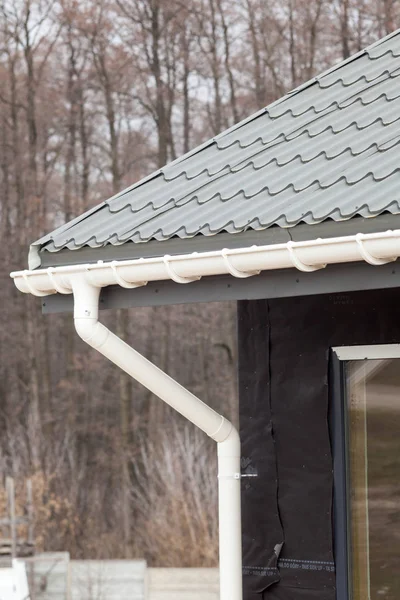 Yeni gri metal kiremit çatı ile beyaz yağmur oluk. — Stok fotoğraf