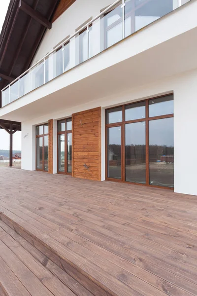 Neues Haus mit weißen Wänden, Holzterrasse und. — Stockfoto