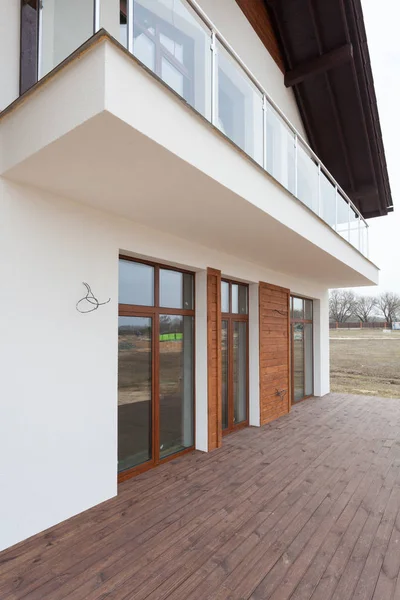 Maison neuve avec murs blancs, terrasse en bois et . — Photo