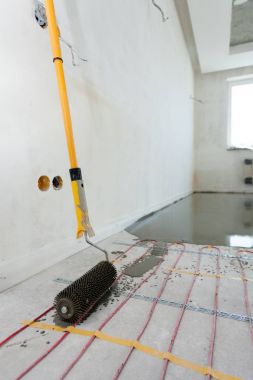 Elektrikli yerden ısıtma sistemi yüklemesi yeni evde. Rooler için closeup hizalamak beton.