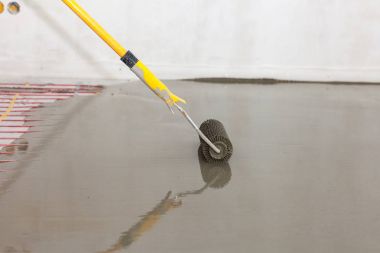 Elektrikli yerden ısıtma sistemi yüklemesi yeni evde. Silindir dökme beton zemin için.