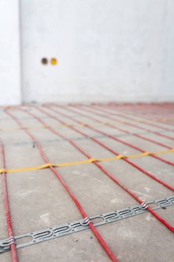 Elektrikli yerden ısıtma sistemi yüklemesi yeni evde. Kırmızı elektrikli tellerin closeup.