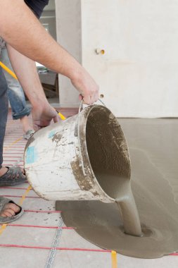 Elektrikli yerden ısıtma sistemi yüklemesi yeni evde. Alt katta beton dökme.