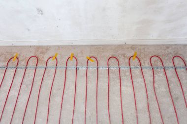 Elektrikli yerden ısıtma sistemi yüklemesi yeni evde. Kırmızı elektrikli tellerin closeup
