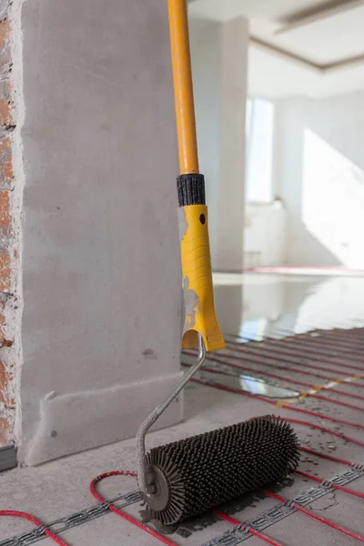 Elektrikli yerden ısıtma sistemi yüklemesi yeni evde. Silindir dökme beton zemin için. — Stok fotoğraf