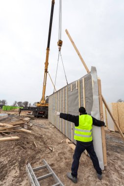 Çatı ustası Oluşturucusu işçi yapısal izolasyonlu paneller SIP yükleme vinç ile. 