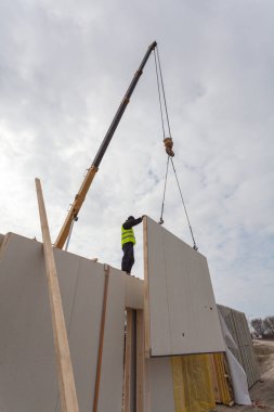 Çatı ustası Oluşturucusu işçi yapısal izolasyonlu paneller SIP yükleme vinç ile. 
