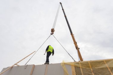 Çatı ustası Oluşturucusu işçi yapısal izolasyonlu paneller SIP yükleme vinç ile. 