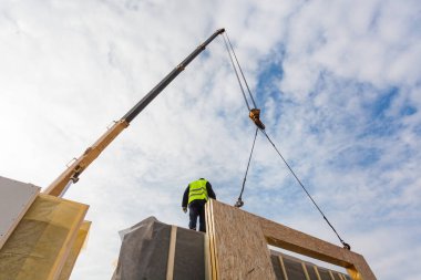 Çatı ustası Oluşturucusu işçi yapısal izolasyonlu paneller SIP yükleme vinç ile. Yapı yeni çerçeve enerji tasarruflu ev