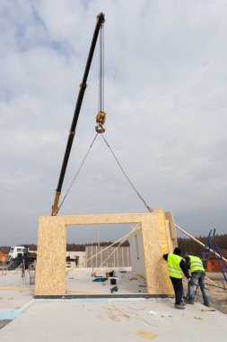 Yapısal izolasyonlu paneller SIP yükleme vinç ile çatı tamircisi Oluşturucusu çalışanları. Yapı yeni çerçeve enerji tasarruflu ev.