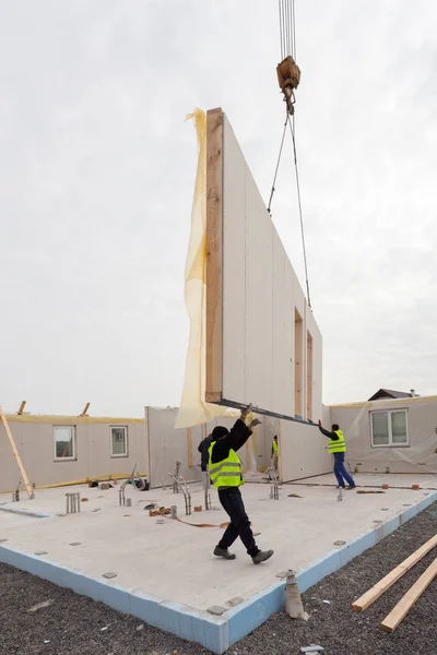 Roofer builder workers with crane installing structural Insulated Panels SIP. Building new frame energy-efficient house