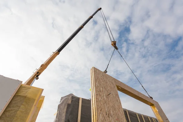 Trabalhador do construtor de telhados com guindaste instalando painéis isolados estruturais SIP. Construção de novo quadro casa eficiente em termos energéticos — Fotografia de Stock