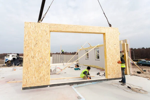Roofer constructor trabajador con grúa instalación de paneles aislados estructurales SIP. Construcción de una nueva vivienda de bajo consumo energético —  Fotos de Stock