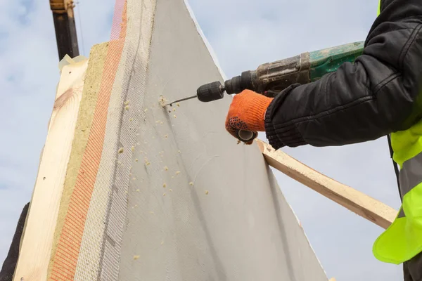 Roofer builder worker use drill to make a hole in structural Insulated Panel — Stock Photo, Image