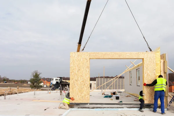 Tetőfedő építő munkások daru telepítése strukturális szigetelt panel Sip. Épület új keret energiatakarékos ház. — Stock Fotó