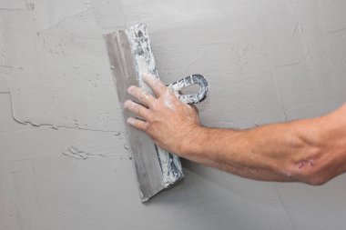 Adam el ile bir duvar sıvama mala.