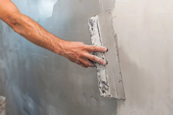 Mano de hombre con paleta enyesando una pared . — Foto de Stock