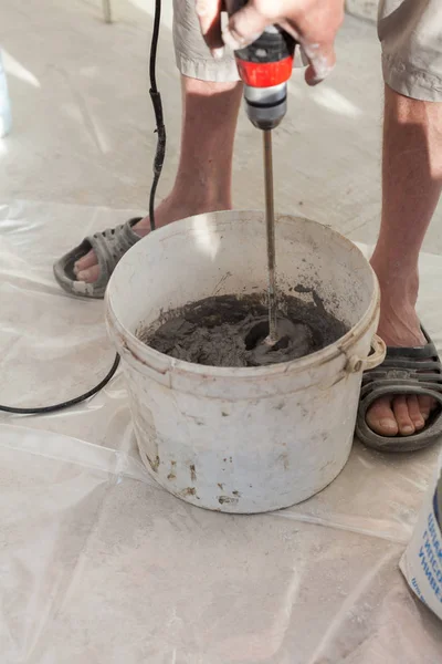 Installation de chauffage au sol électrique dans une maison neuve. Travailleur utiliser bétonnière à main pour préparer le ciment . — Photo