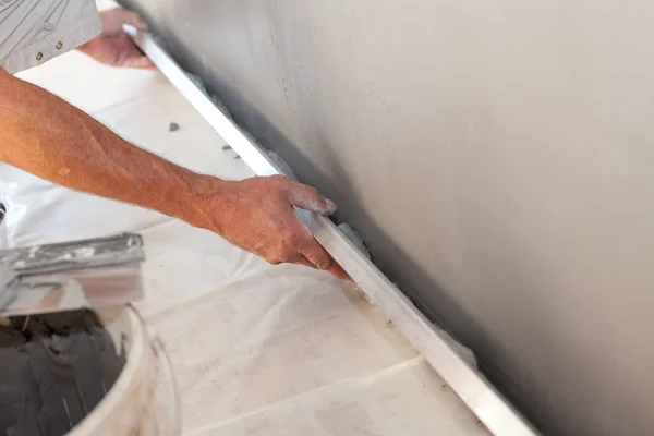 Tamirci el uzun mala ile bir duvar sıvama closeup — Stok fotoğraf