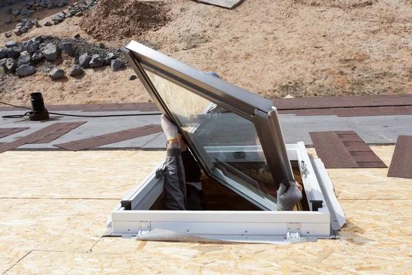 新しいプラスチック (マンサード) または天窓をインストールするアスファルト鉄片屋根上の労働者 — ストック写真