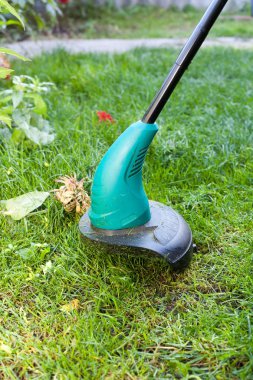 Çalışan bir çim biçme makinesi mows. Yeşil çim biçme makinesi yakın çekim.