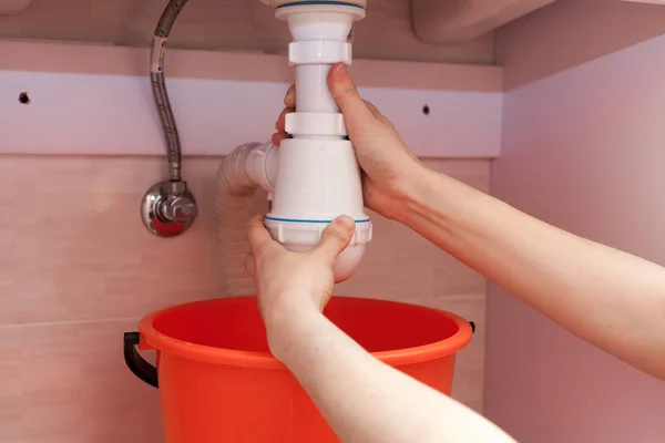 Femeie mâini cu sticlă de detergent de curățare pentru chiuvetă metalică în bucătărie — Fotografie, imagine de stoc