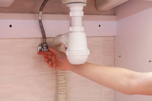 Manos de mujer con botella de detergente de limpieza para fregadero de metal en cocina — Foto de Stock