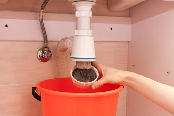 Manos de mujer con botella de detergente de limpieza para fregadero de metal en cocina — Foto de Stock