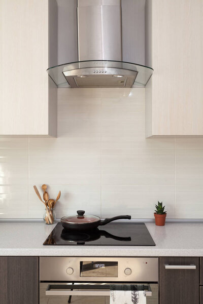 Женские руки с бутылкой моющего средства для металлической раковины на кухне
