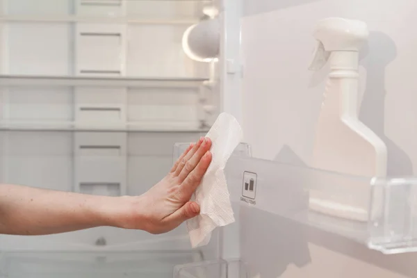 Женские руки с бутылкой моющего средства для металлической раковины на кухне — стоковое фото