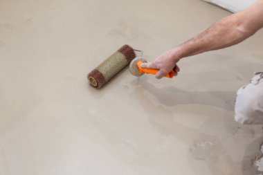 İş onarın. Kat odasında dökme. Şap kat onarım doldurun ve vermek. İşçi çimento ile silindir hizalama.