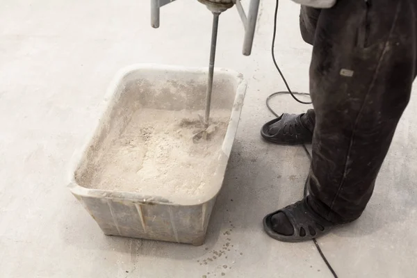 Travaux de réparation. Verser des planchers dans la pièce. Remplissez plancher de chape réparer et meubler. Travailleur utiliser bétonnière à main pour préparer le ciment . — Photo