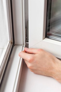 Tamirci bir Altıgen ile plastik pencere onarır. İşçi plastik pencere işlemi ayarlar.