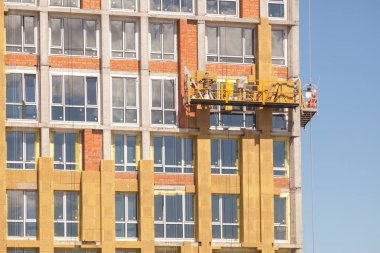 Mineral Taş yünü yüklemesi ile ev cephe yalıtım inşaat işçileri. Dış duvar yalıtım sistemi (veya Ewis) mineral yün enerji tasarrufu için