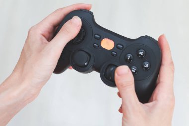 Bir kadın bir joystick tutuyor. Elinde beyaz bir arka plan üzerinde gamepad.