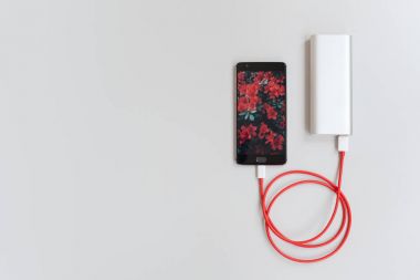 Beyaz masa üzerinde güç banka ile şarj Smartphone.