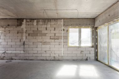 Yeni ev yapım aşamasında. Gaz beton bloklar, çimento tuğla duvarlar, plastik pencere, elektrik kablolama yükleme. Boş odada kapsayan çimento