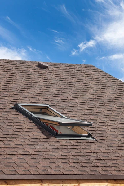 Roof with mansard windows and asphalt shingles.