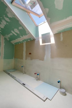 Yenilenmiş daire kabilelerini bitirme. Tesisat borularının mansard pencere ile banyoda