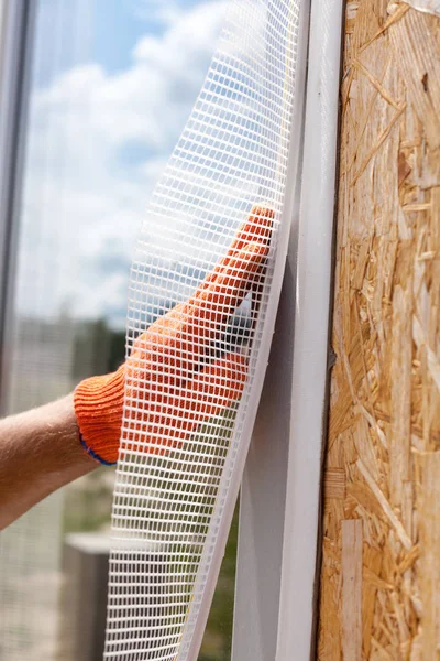 建筑工人戴着手套 在窗户上安装一个特殊的格子 建筑装修工程 — 图库照片