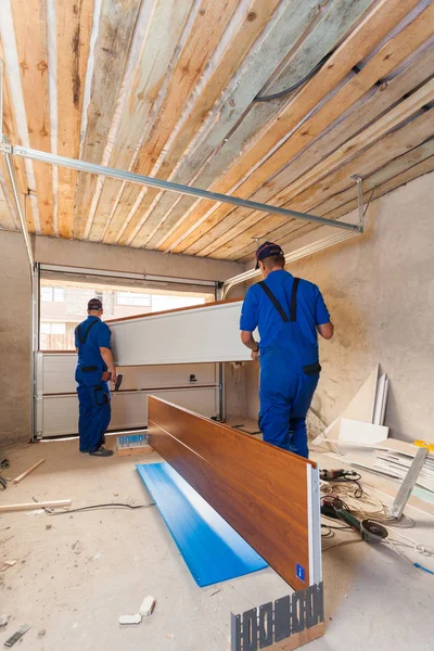 Garage doors installation.Workers installing lifting system