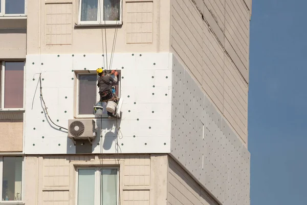 Wall Thermal insulation, industrial climbing, high-altitude work, insulation of walls with foam plastic or Styrofoam
