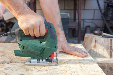 İnşaat işçisi kullanın jig saw bir ahşap Sunta veya Sunta kesme için 