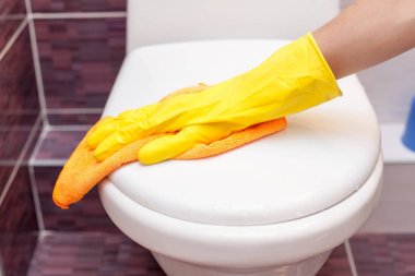 Tuvalet koltuk kapak turuncu bez ile temizlik sarı lastik eldiven kadında. Banyo ve tuvalet hijyen