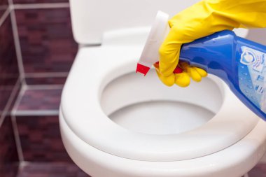 Tuvalet koltuk kapak turuncu kumaş ve deterjan ile temizlik sarı lastik eldiven kadında. Banyo ve tuvalet hijyen