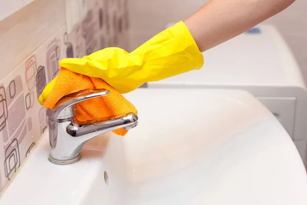 Frauenhände Mit Gelben Gummischutzhandschuhen Reinigen Wasserhahn Mit Orangefarbenem Tuch — Stockfoto