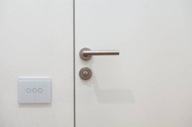 Işık düğmesini yanındaki kapı kolu. Metal saplı beyaz kapıyı açın.