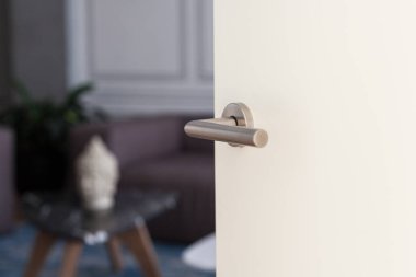 Metal saplı beyaz kapıyı açın. Yatak odası kapısı