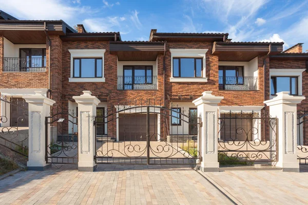 Modern brick house with plastic windows, modern wrought-iron gates and chimney — Stock Image Modern Brick House Plastic Windows Modern Wrought Iron Gates Chimney Royalty Free Stock Images