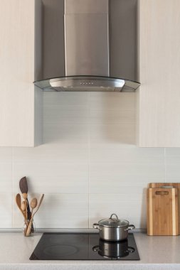 Bir seramik tabak extractor kukuleta ile yeni modern mutfakta yemek tava yanıyor